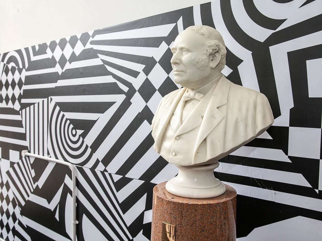 bust of John Gray in front of patterned background