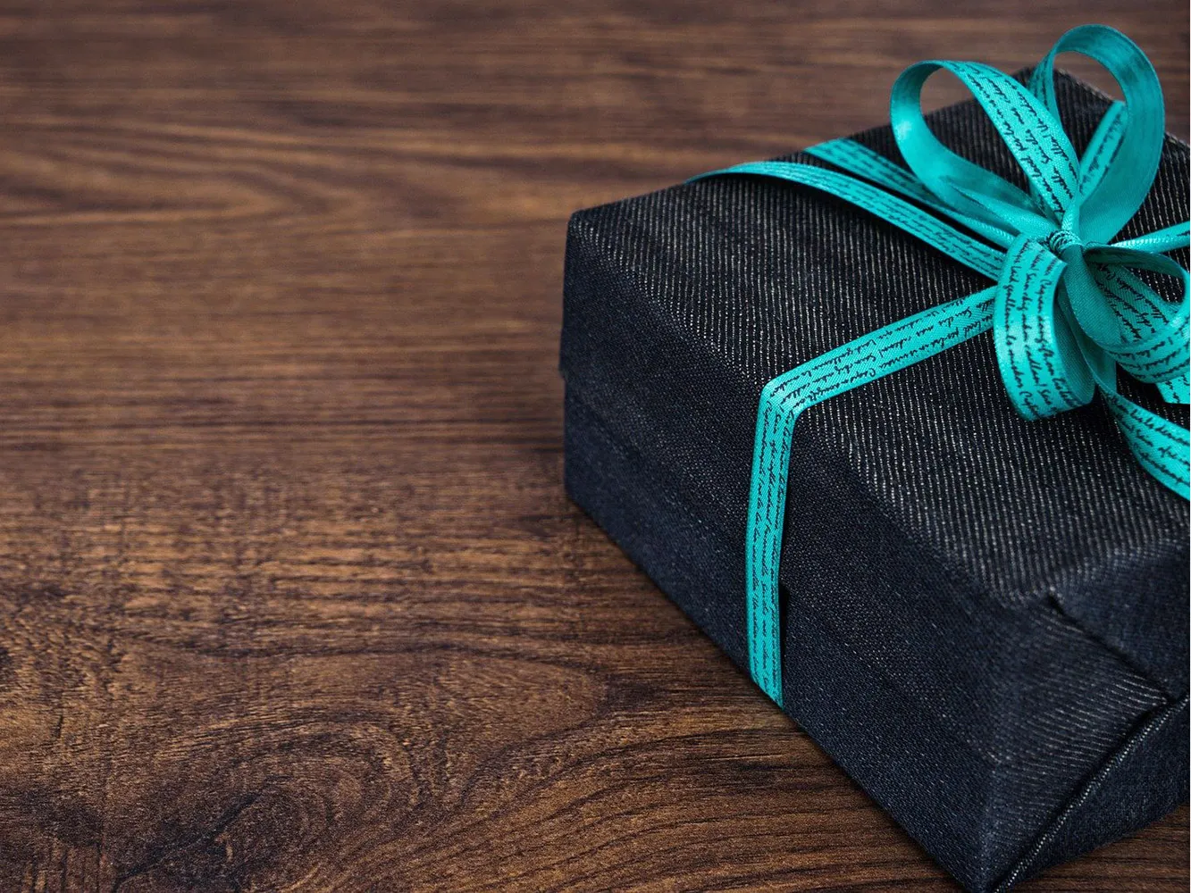 black box gift wrapped with blue ribbon