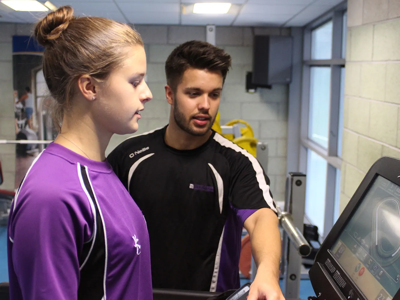 person speaking to person on a treadmill