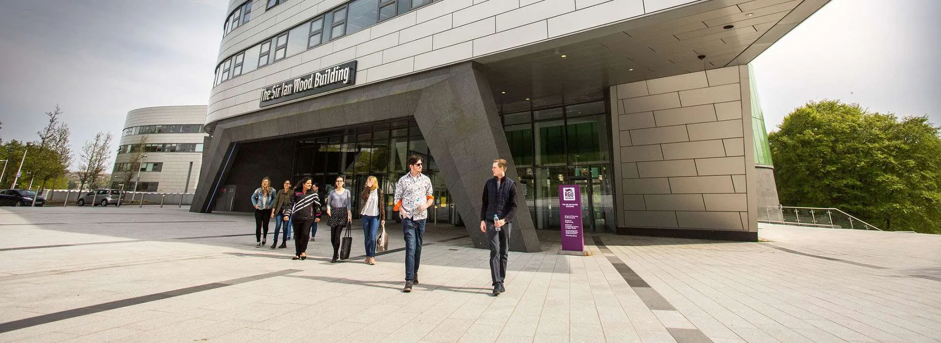 students walking out of the sir ian wood building