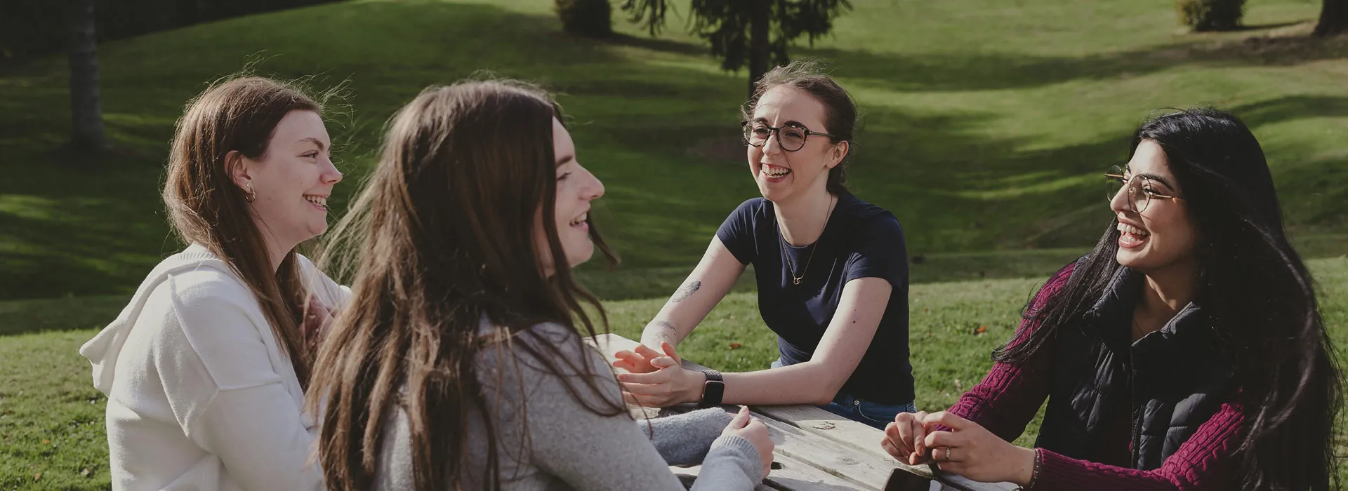 students chatting on a picnic bench