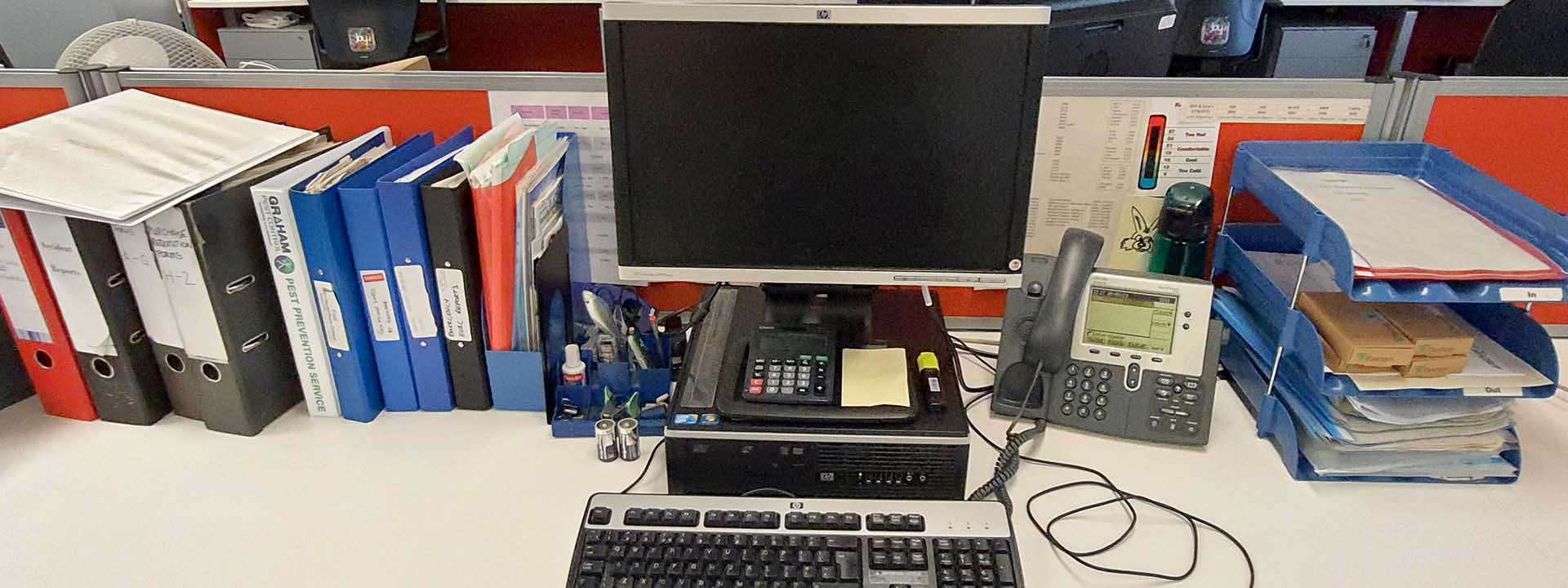 a desk with pc and folders