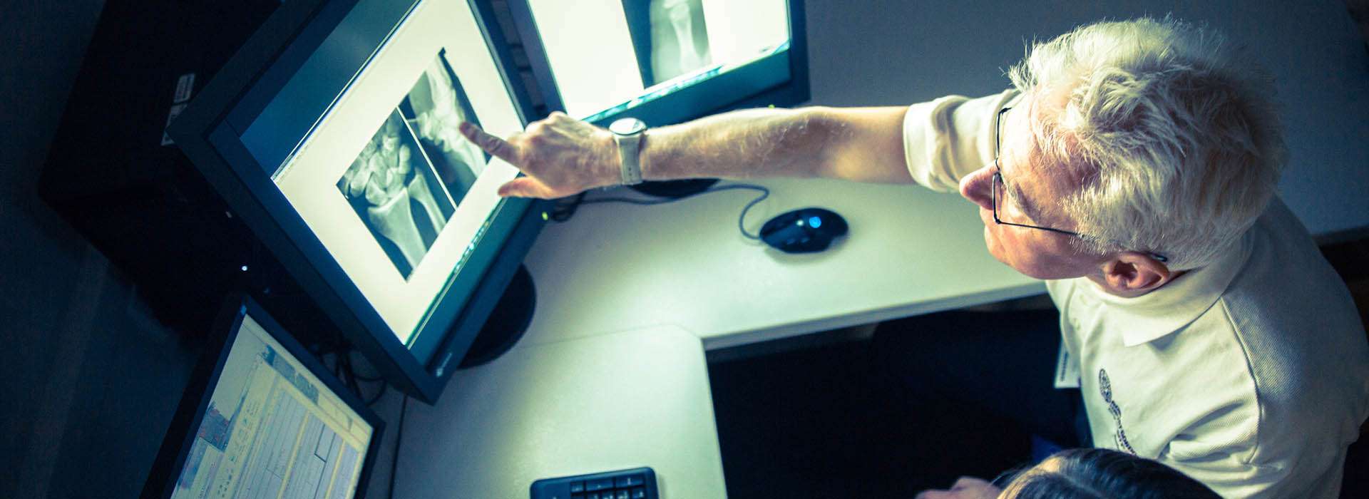 person pointing to an x-ray on a screen