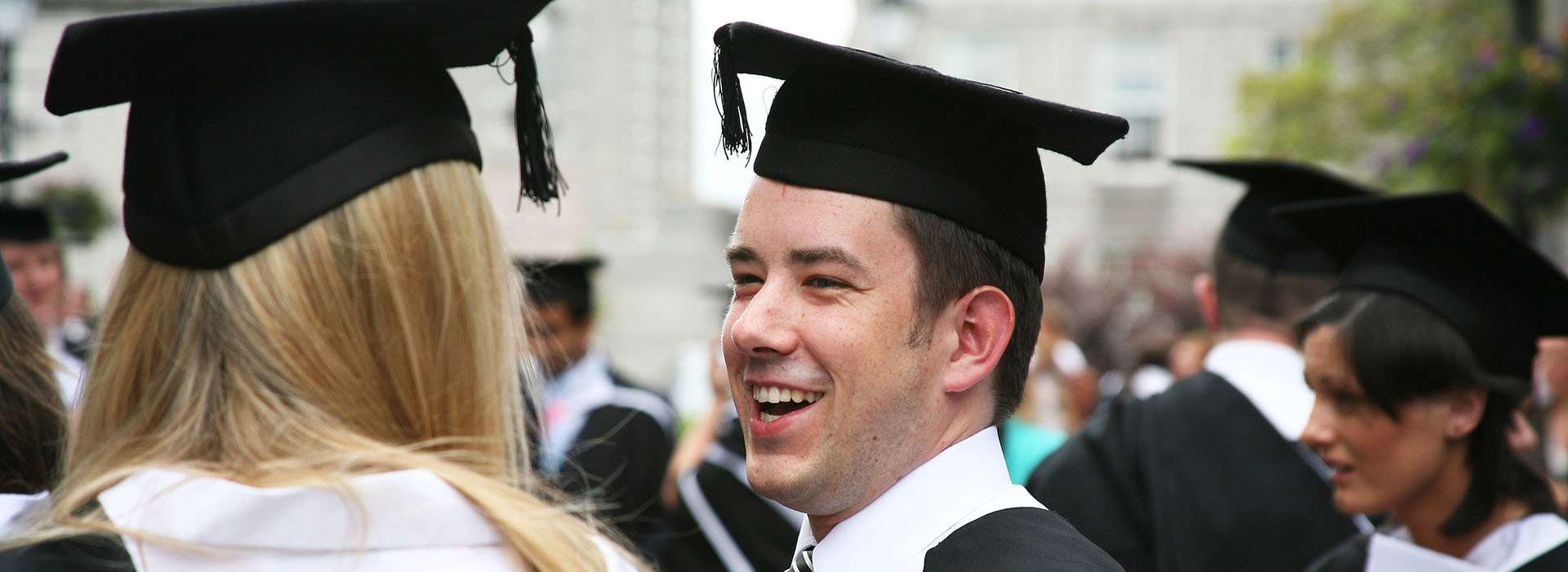Graduates smiling at one another