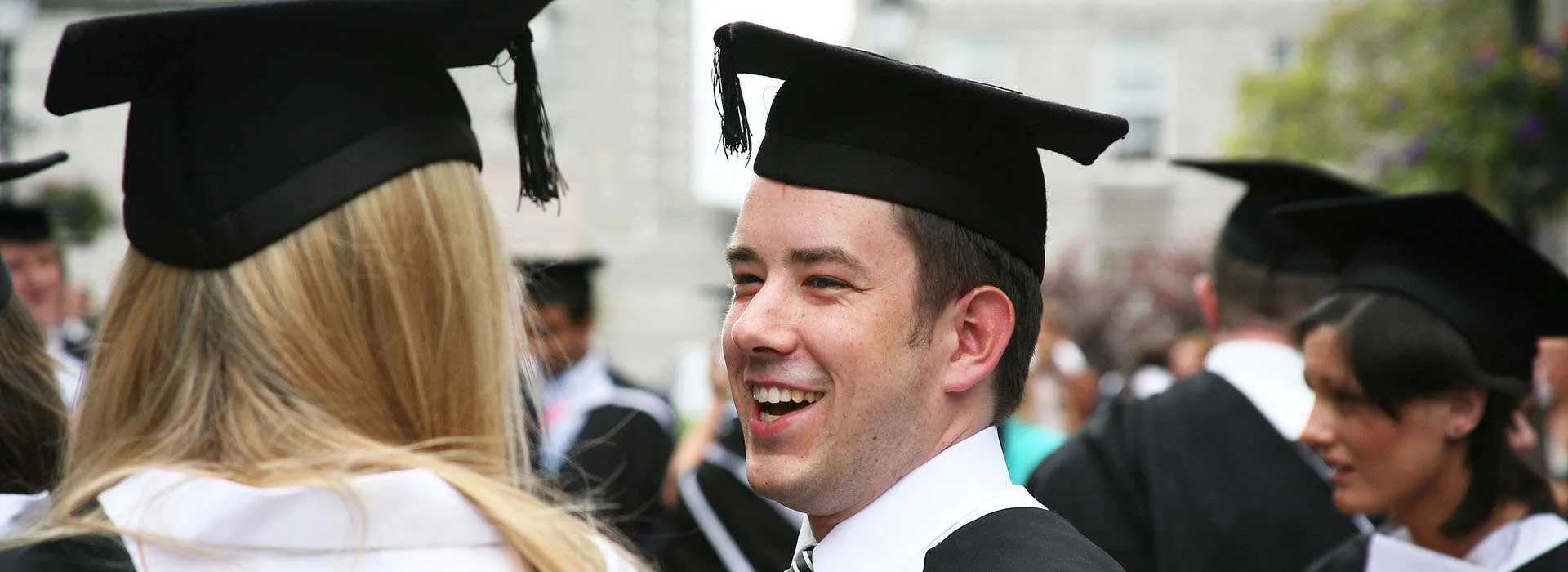 Graduates smiling at one another
