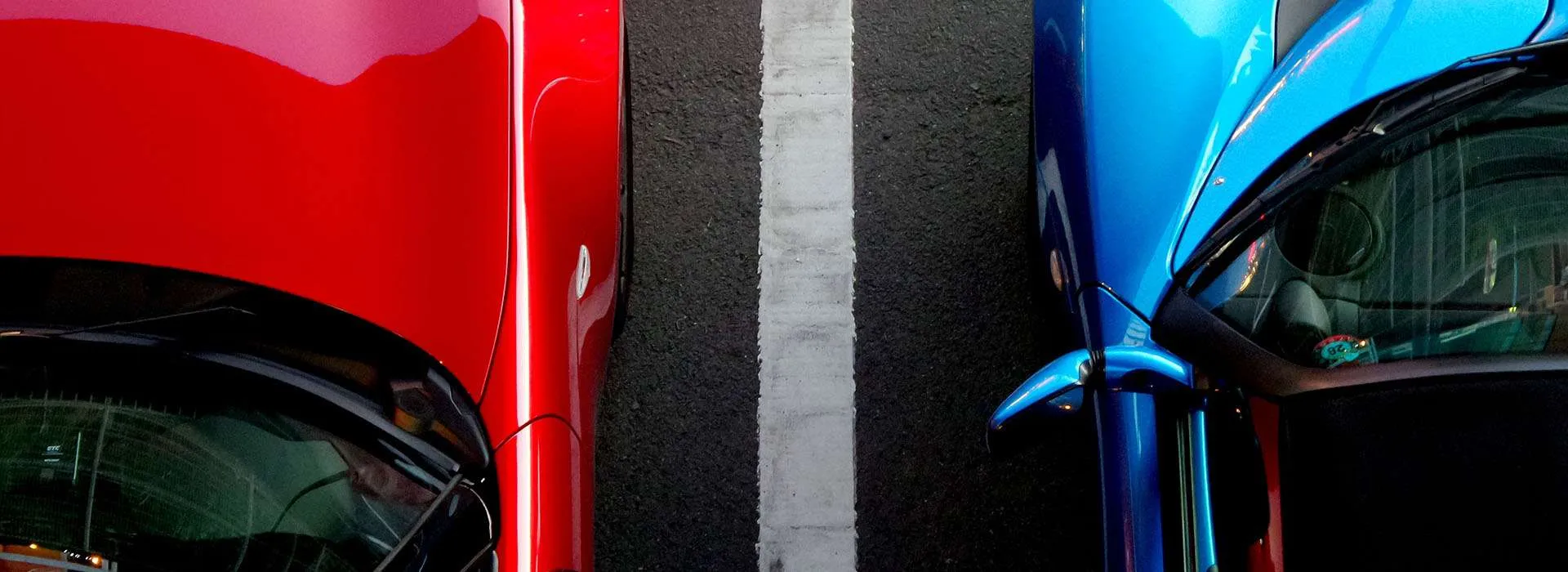 blue and red car parked next to one another