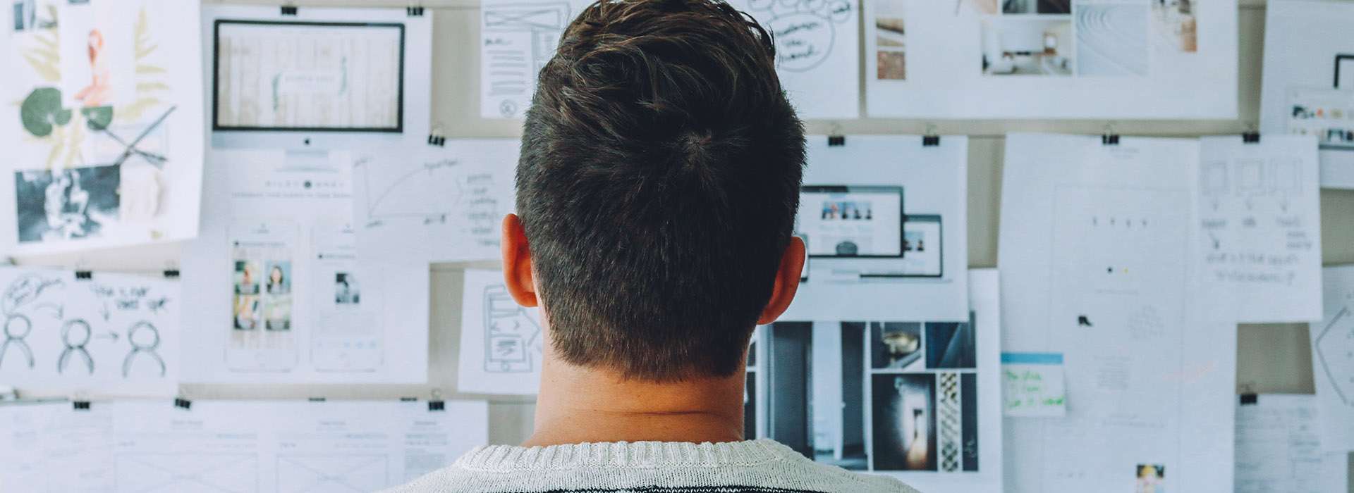 person looking up at a whiteboard with plans and notes on