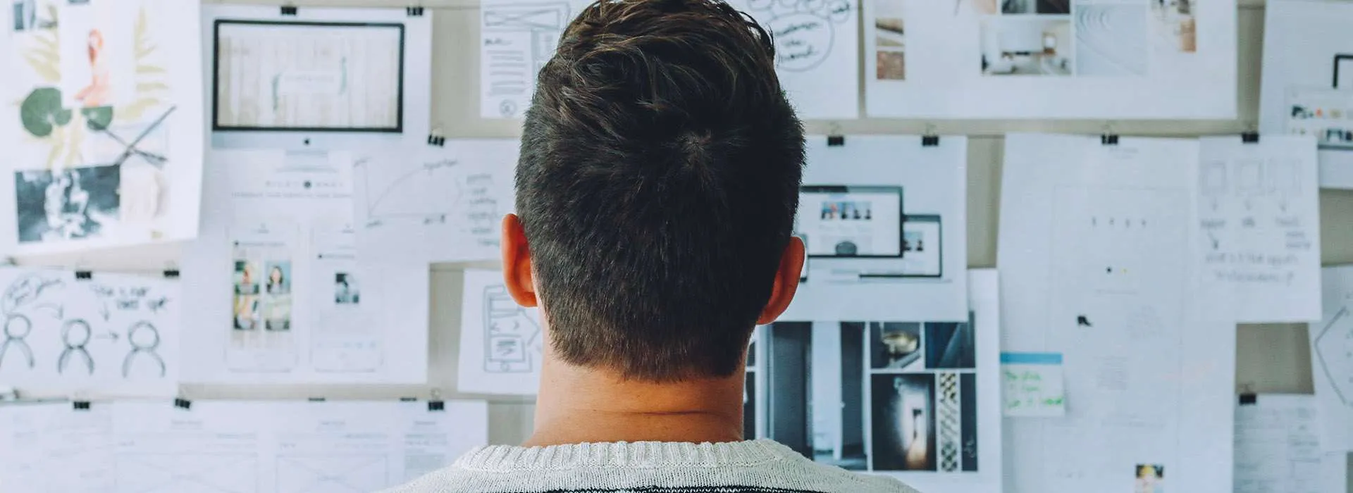 person looking up at a whiteboard with plans and notes on