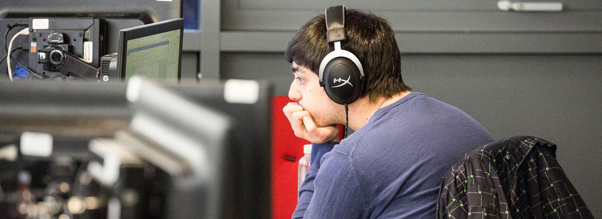 student wearing headset looking at computer screen