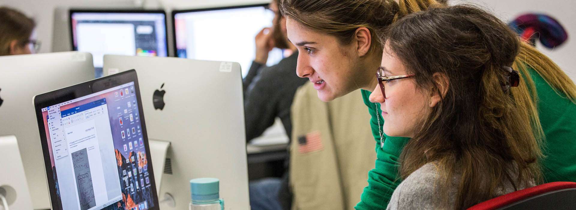 students looking at a mac screen together