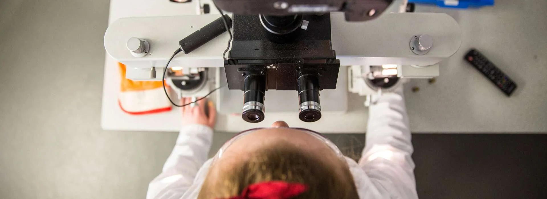 student looking through microscope