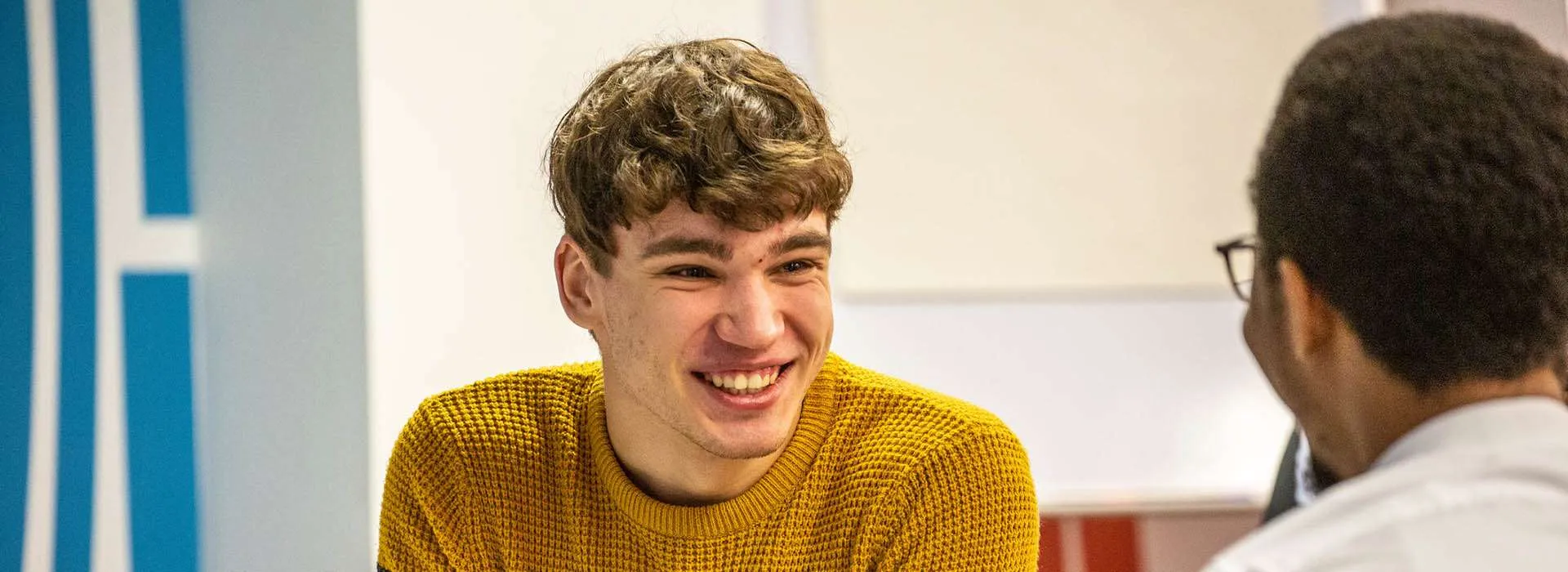 two students smiling having a conversation