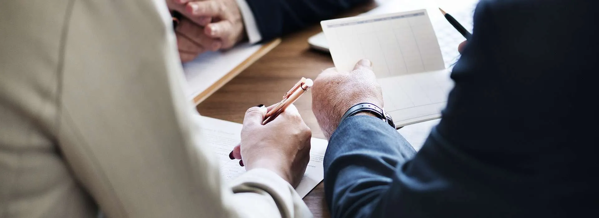 people looking over documents on a table