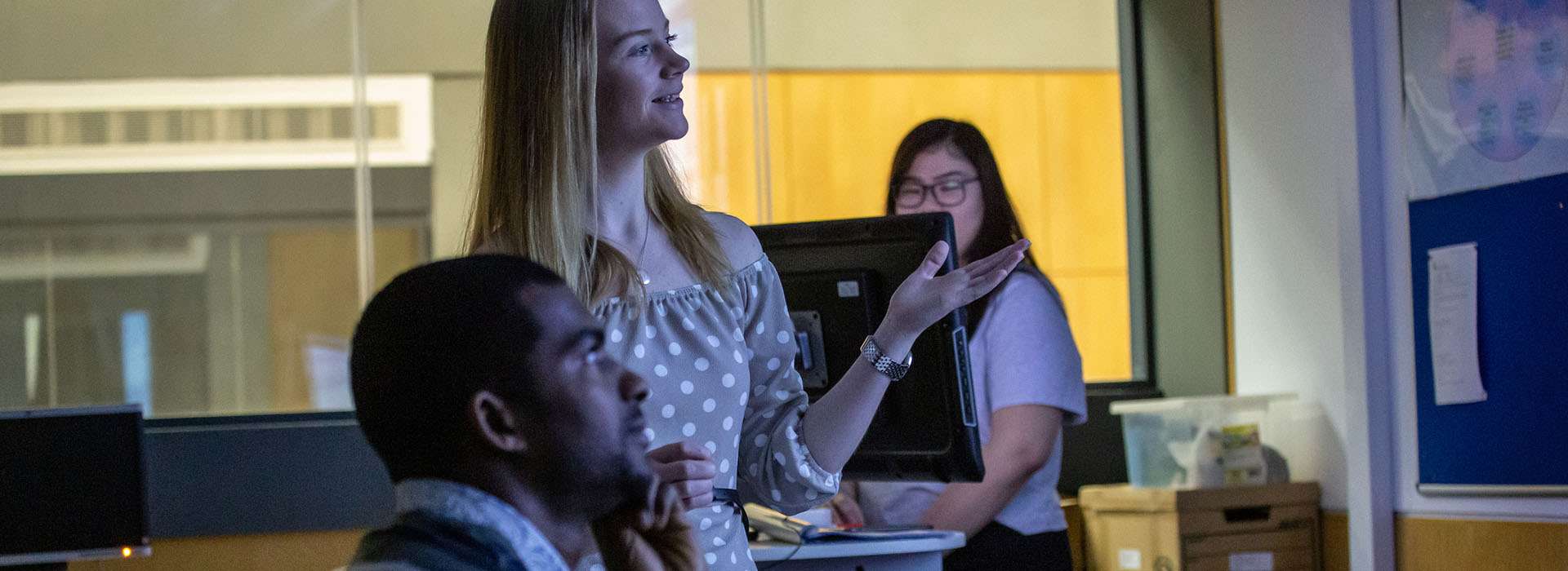 lecturer in the classroom explaining something to a student