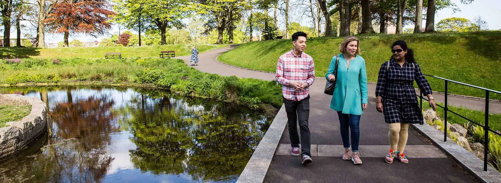 three people walk through Aberdeen's Duthie Park
