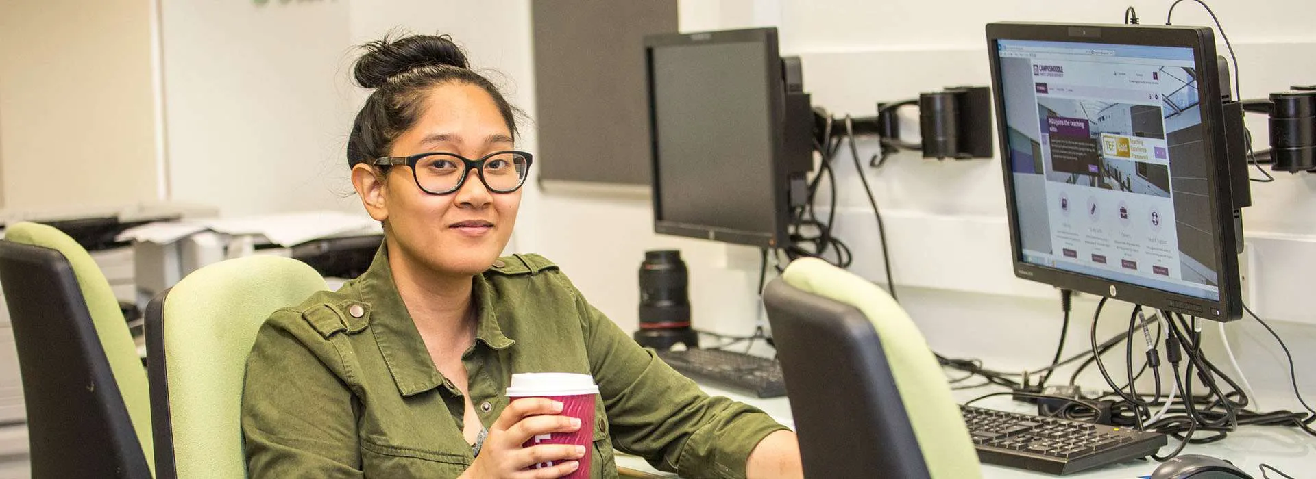 student sitting at a computer with a coffee