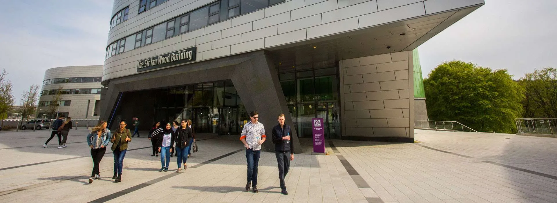 students walking out of sir ian wood building