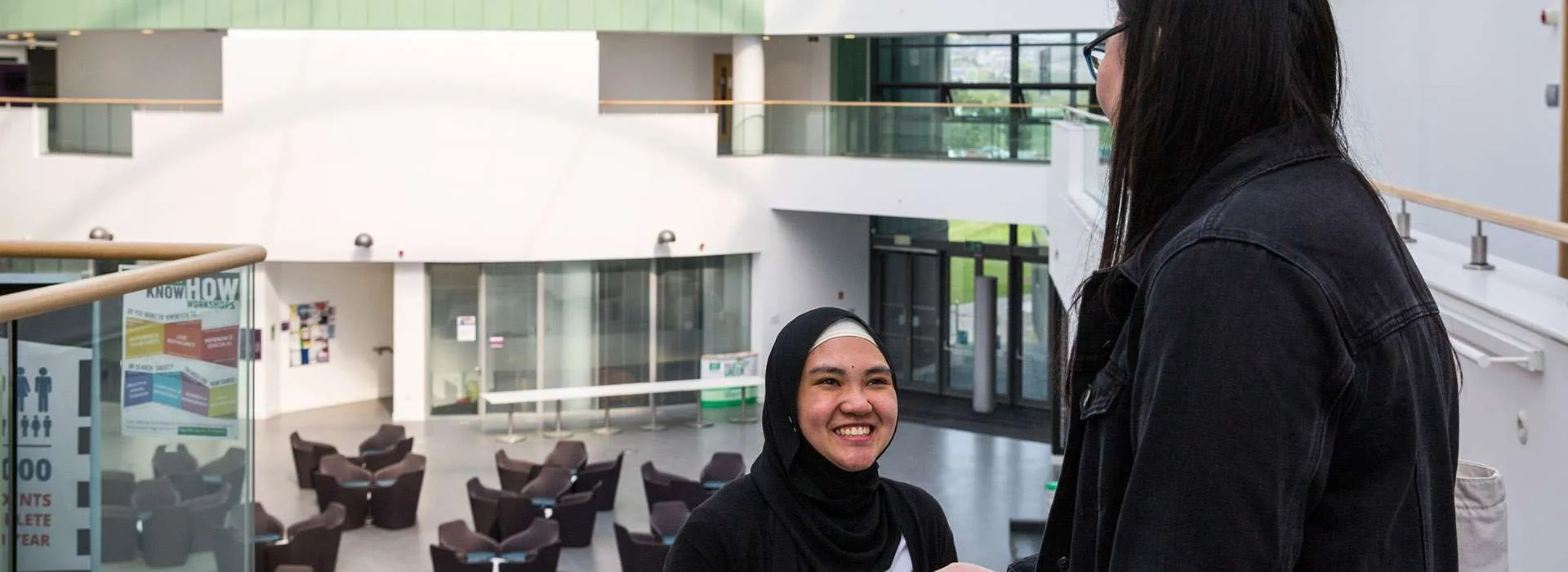 students wearing headscarves in the back atrium of sir ian wood building