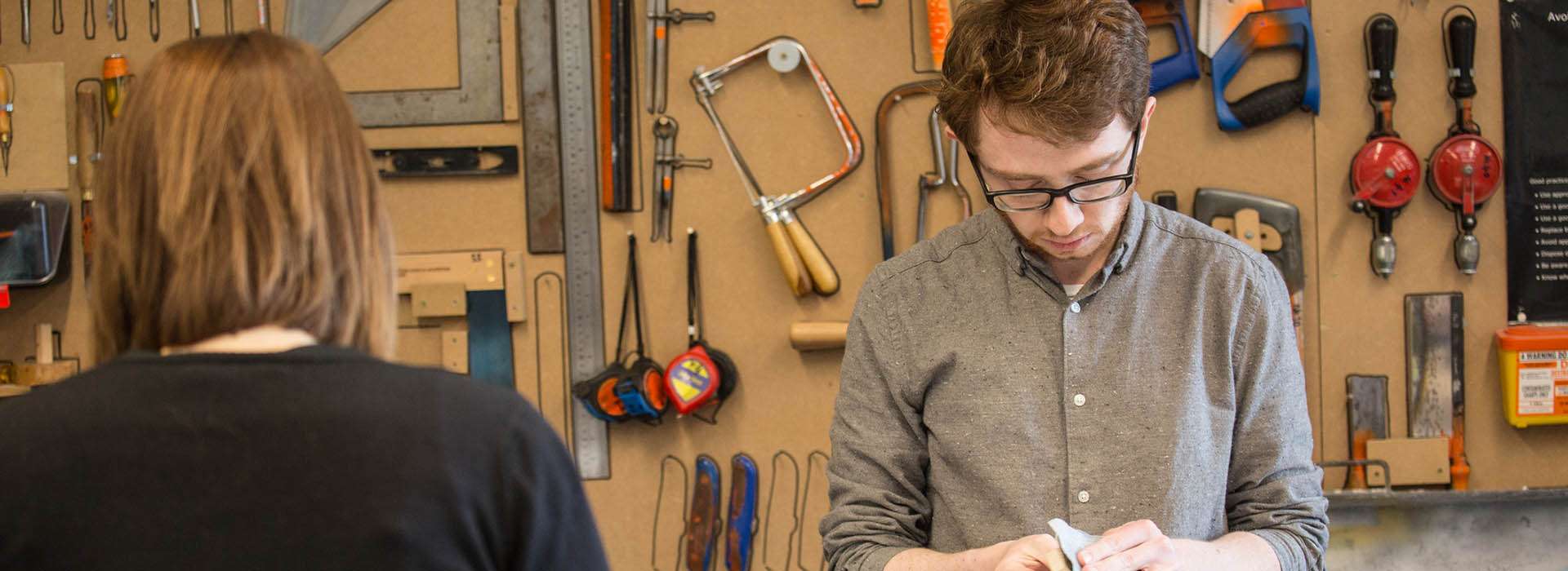 students working in front of a wall of tools