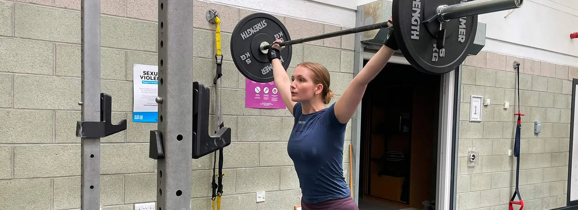 female student lifting barbell