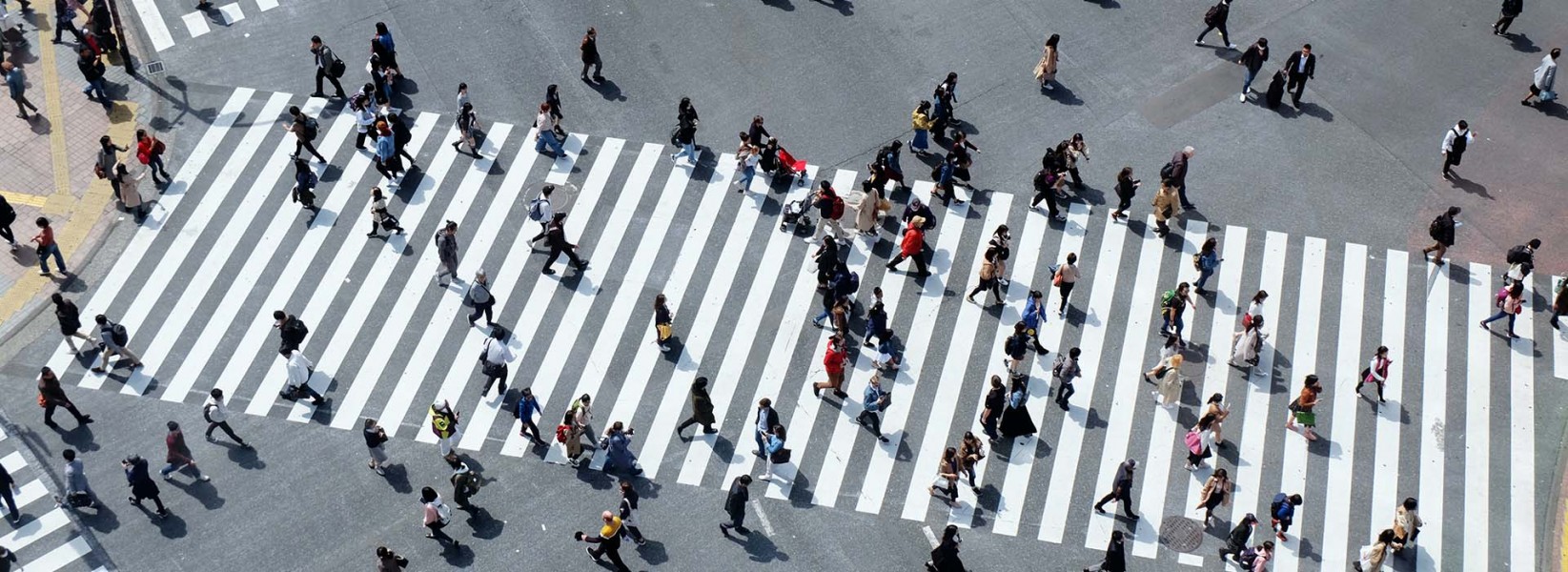people walk along a busy crosswalk