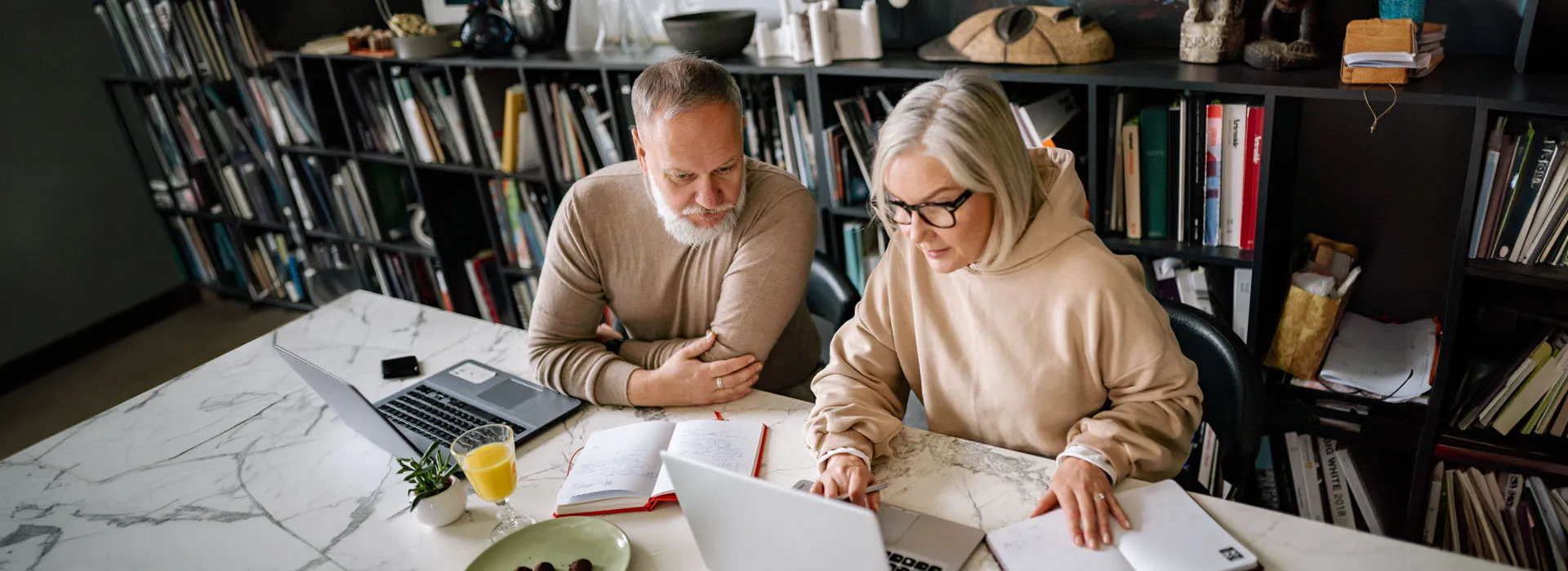 older people working on laptops at a desk