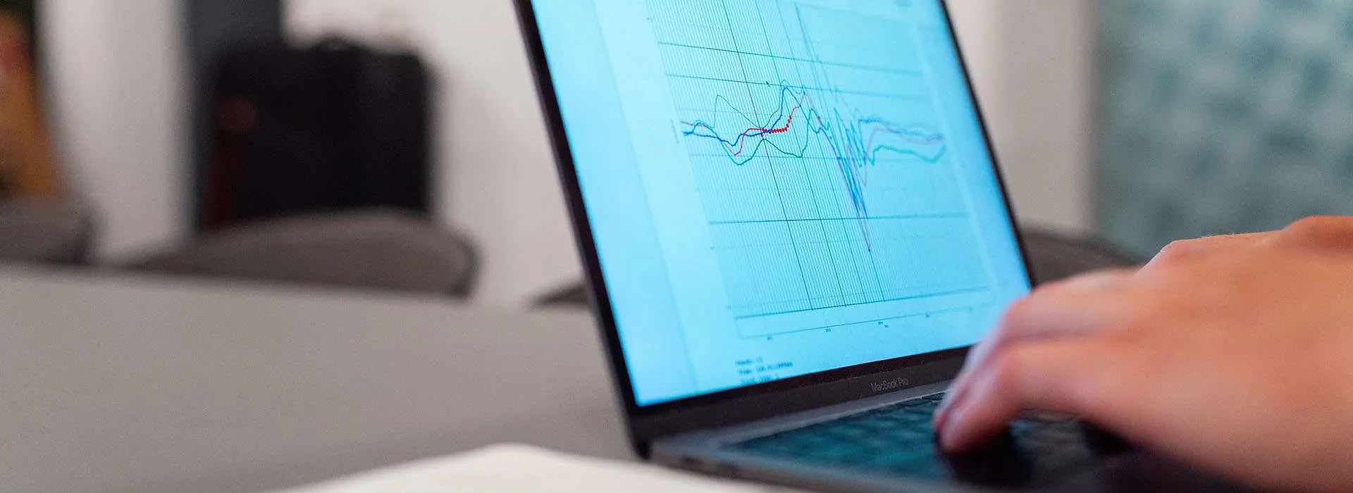 person using a laptop with a graph on the screen