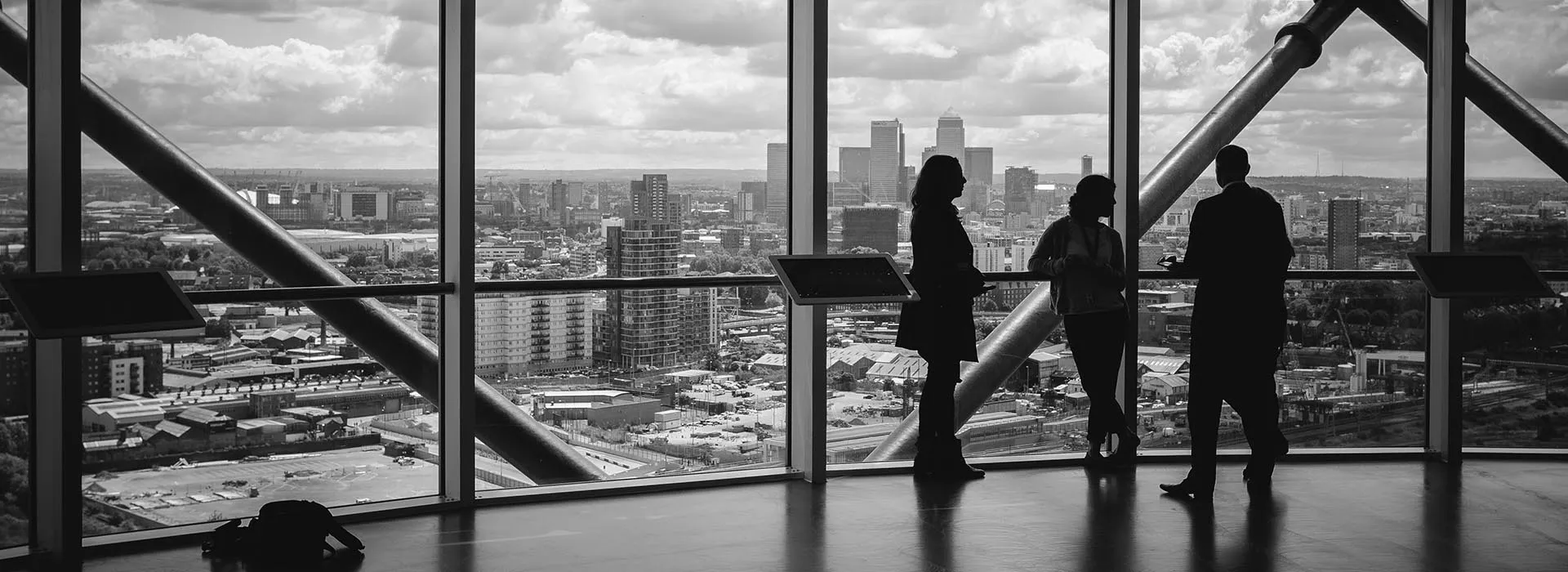 People standing by a window of a high rise building