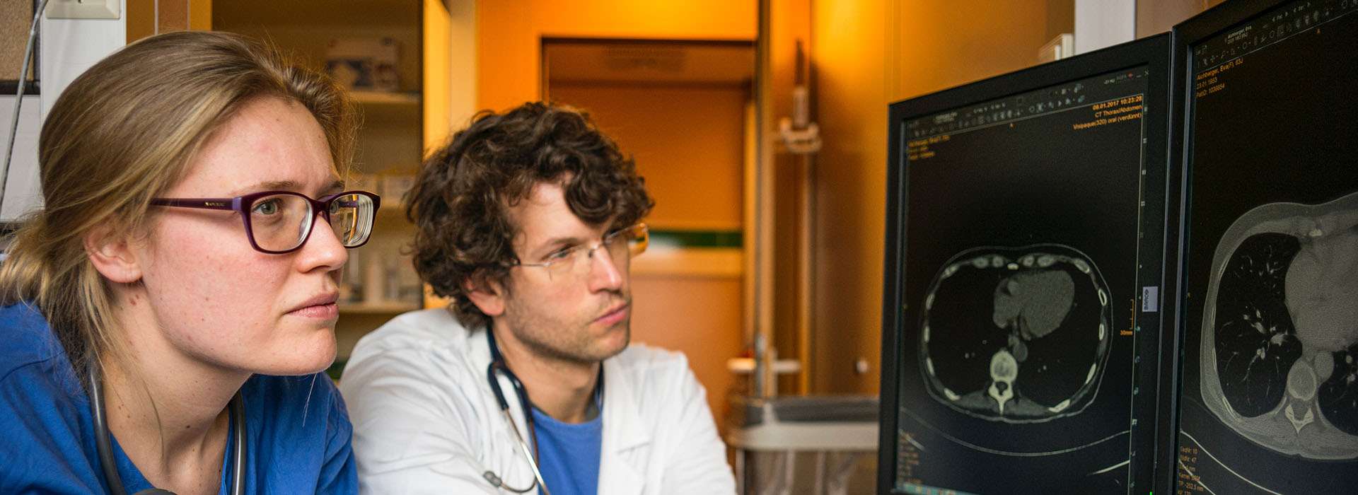 two health professionals looking at a body scan
