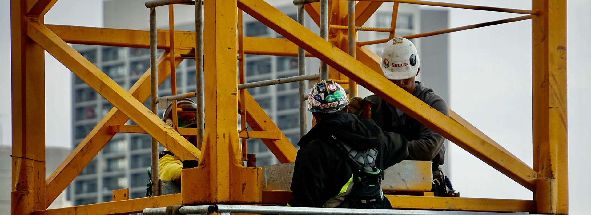 two workers on a yellow crane