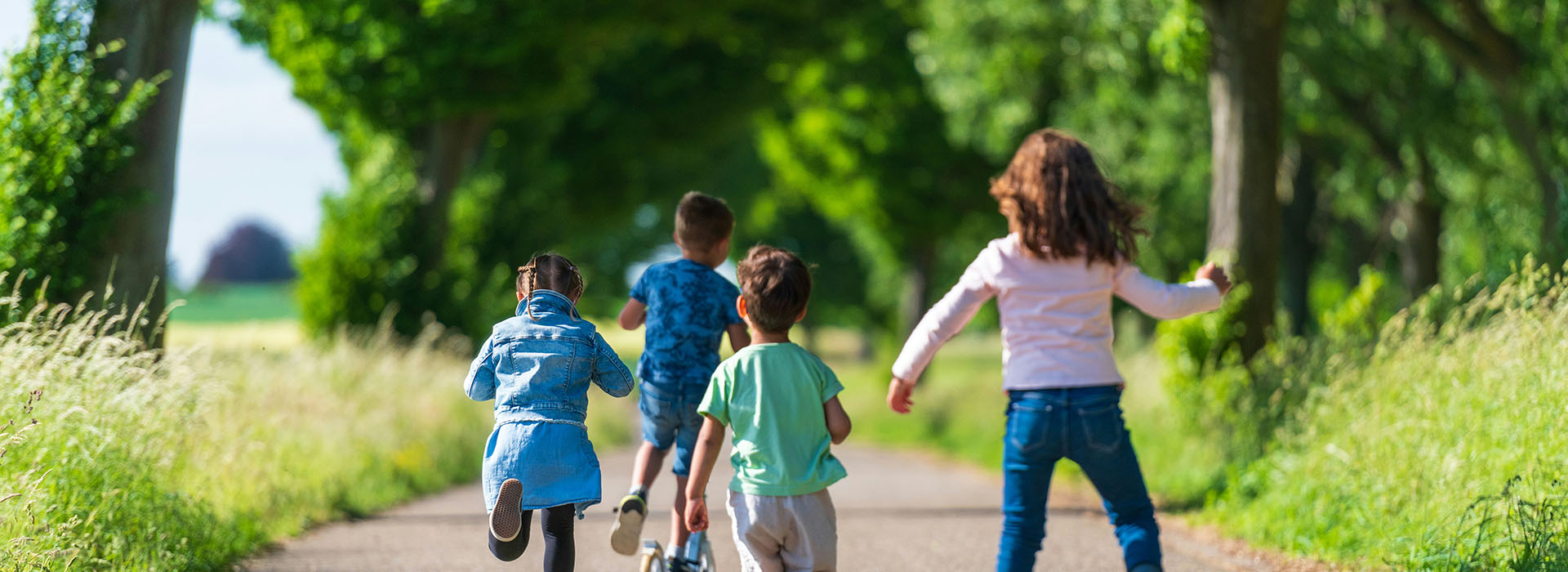 Children skating and running down a path