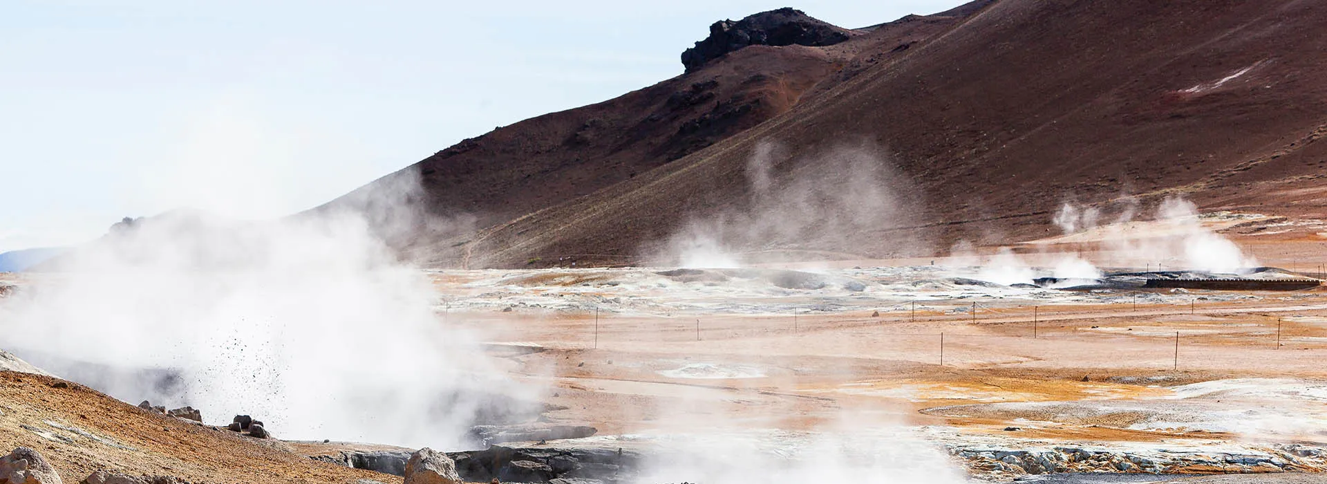 a hillside landscape with air vents causing gas clouds