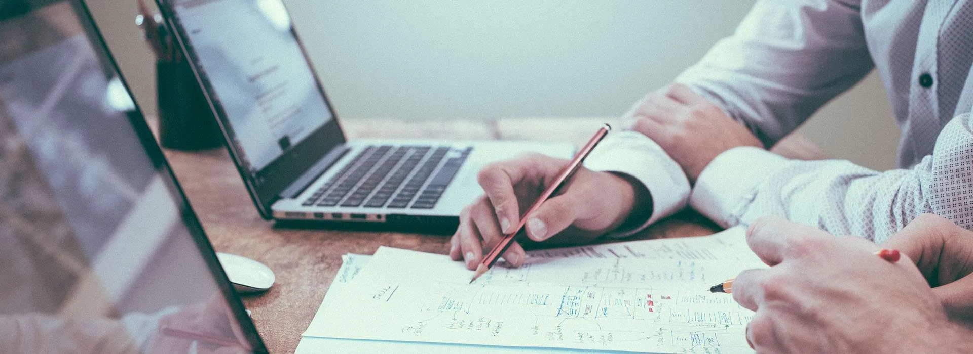 Person holding a pencil at a meeting