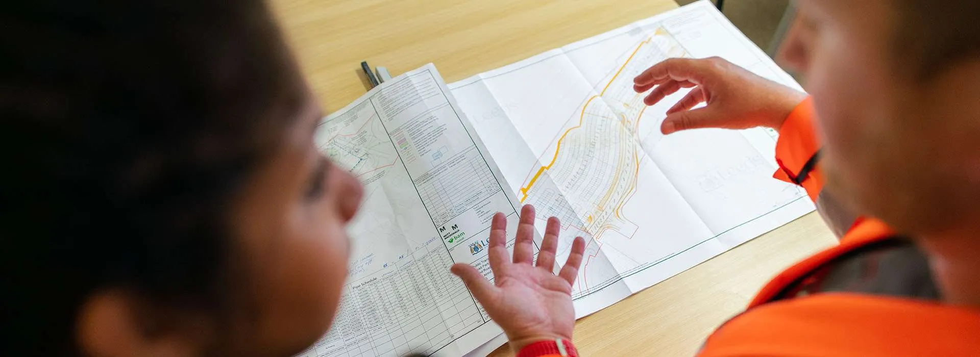 two people chatting next to a technical drawing