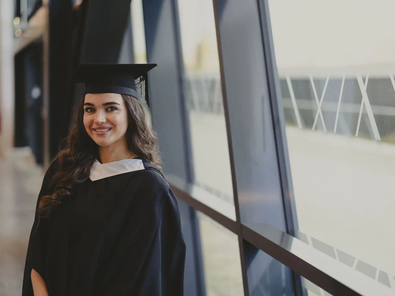 Kirsty Stewart smiling in graduation robes and hat