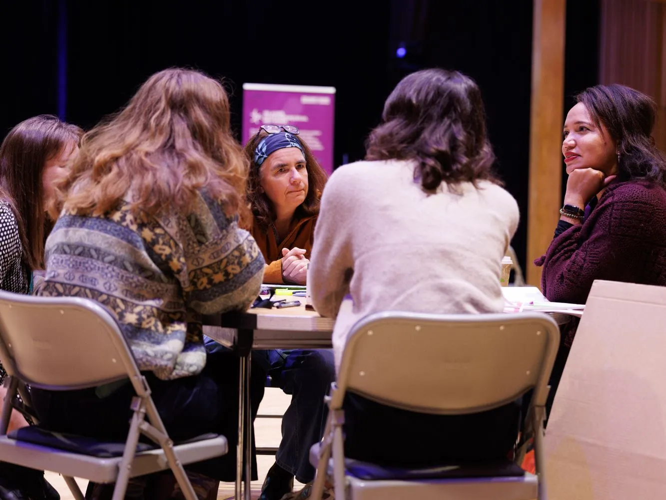 Participants sitting around a table having a discussion