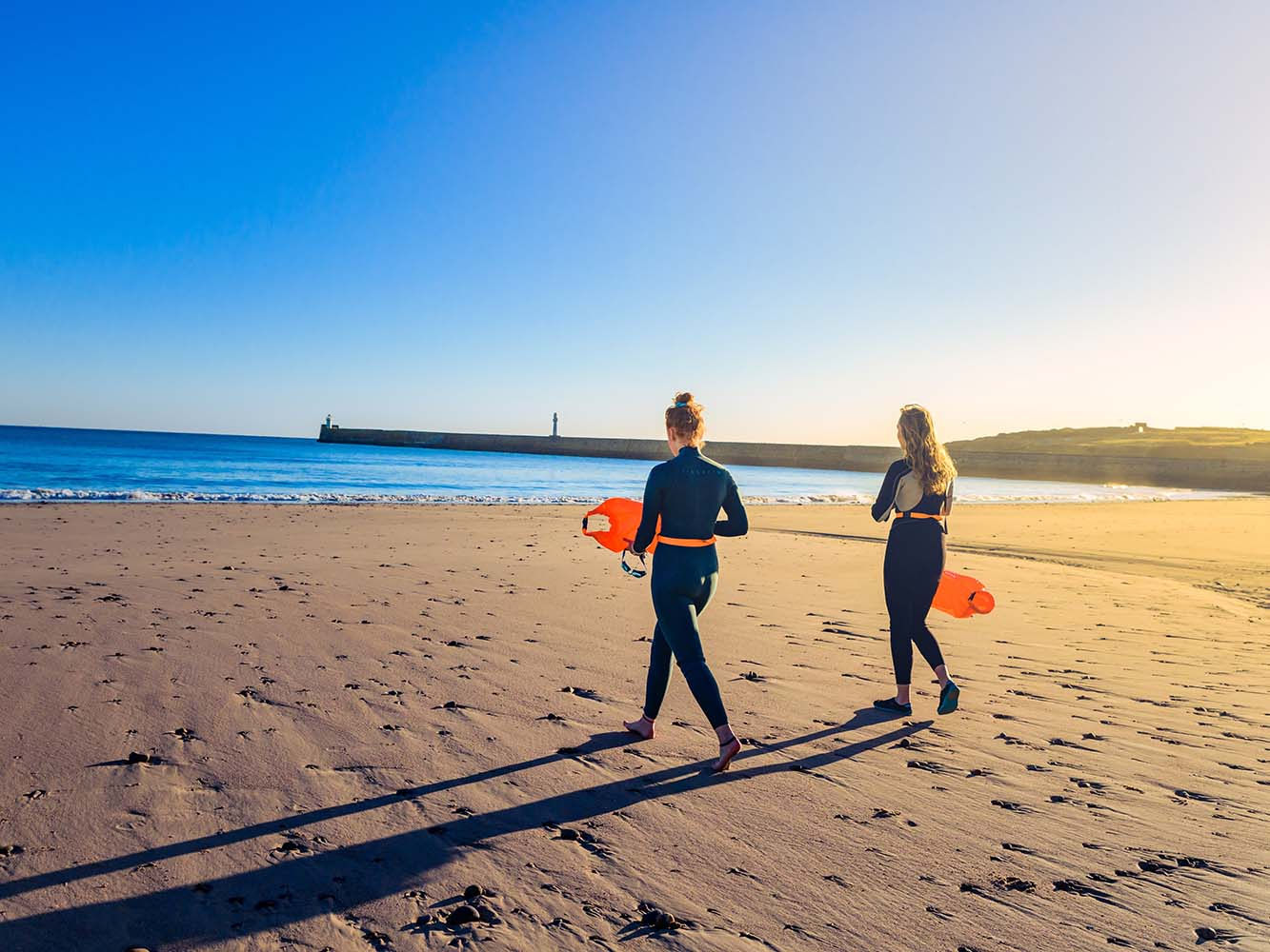 Two surfers walking down Aberdeen beach