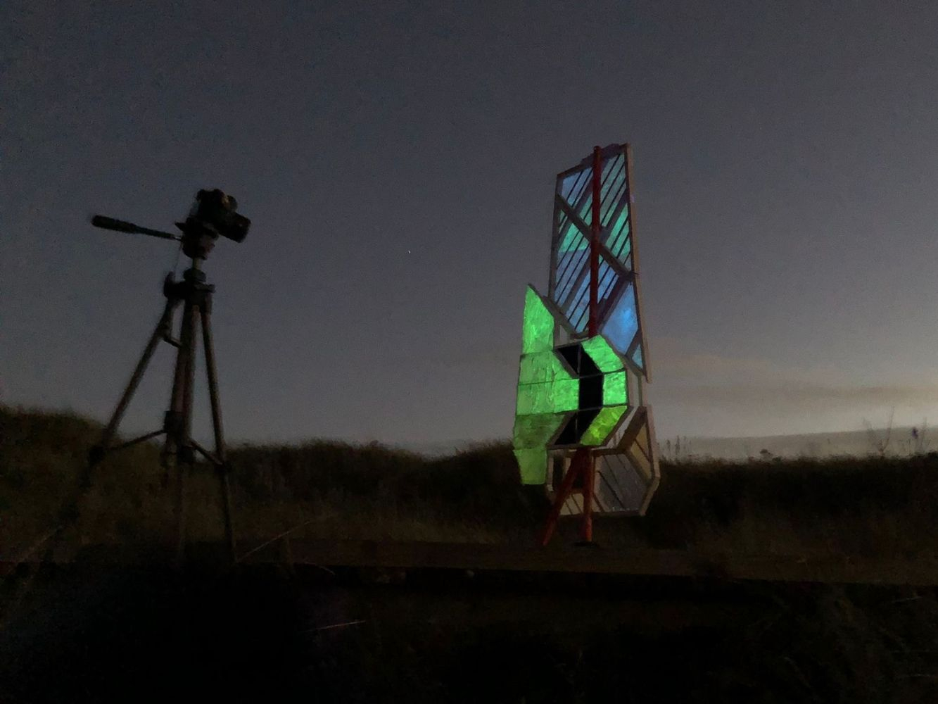 A camera points towards an invented wooden structure, located on a North East hill in the dark