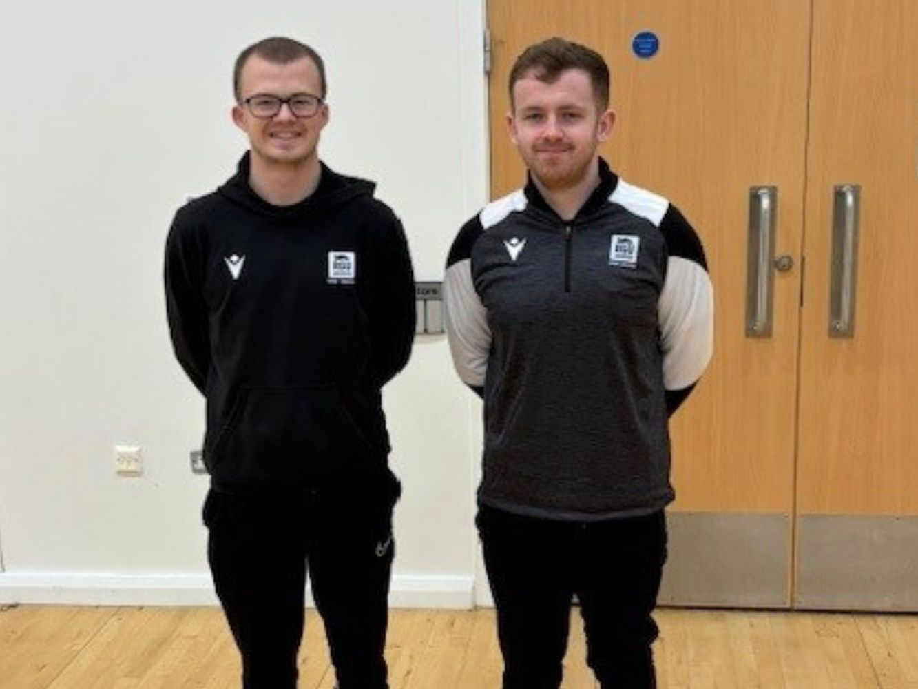 Reece Hurrell and Robert Cruickshank standing together in a sports hall