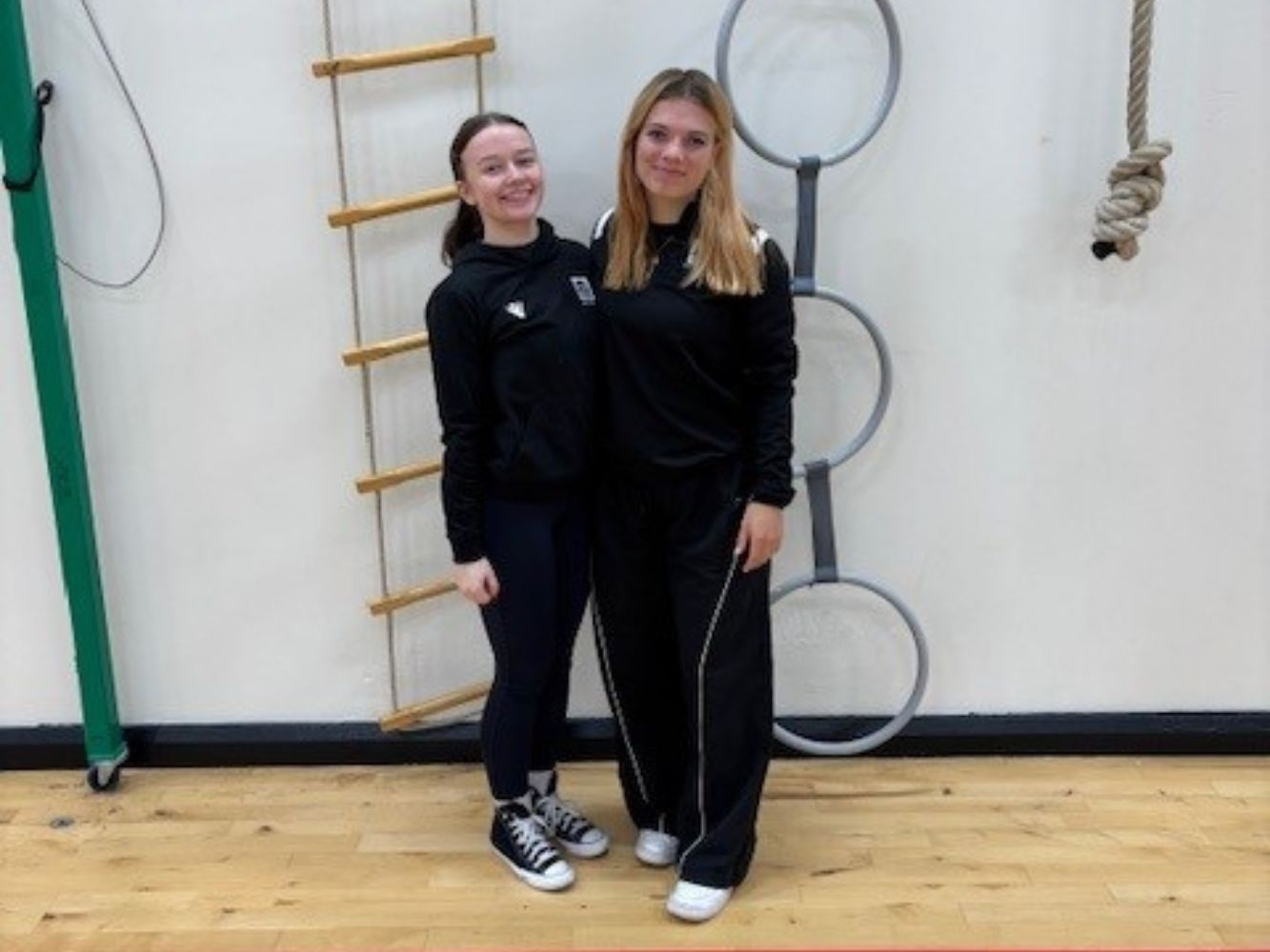 Abigail Deeming (Stage 4) and Joanna Hewitt (Stage 3) stand together in a sports hall