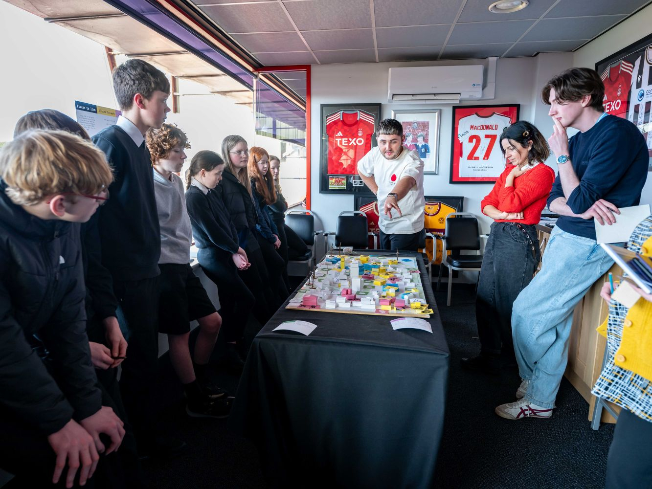 Staff and school children together discussing the activity at hand