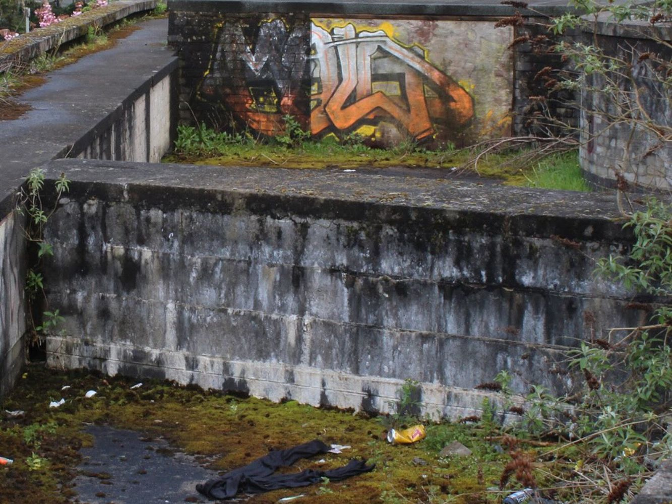 The current Upper Denburn Gardens scene shows overgrown plants, graffiti and uncared for concrete