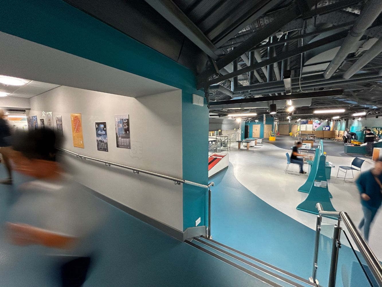 The posters in situ in Aberdeen Science Centre with blurred passers by in the background