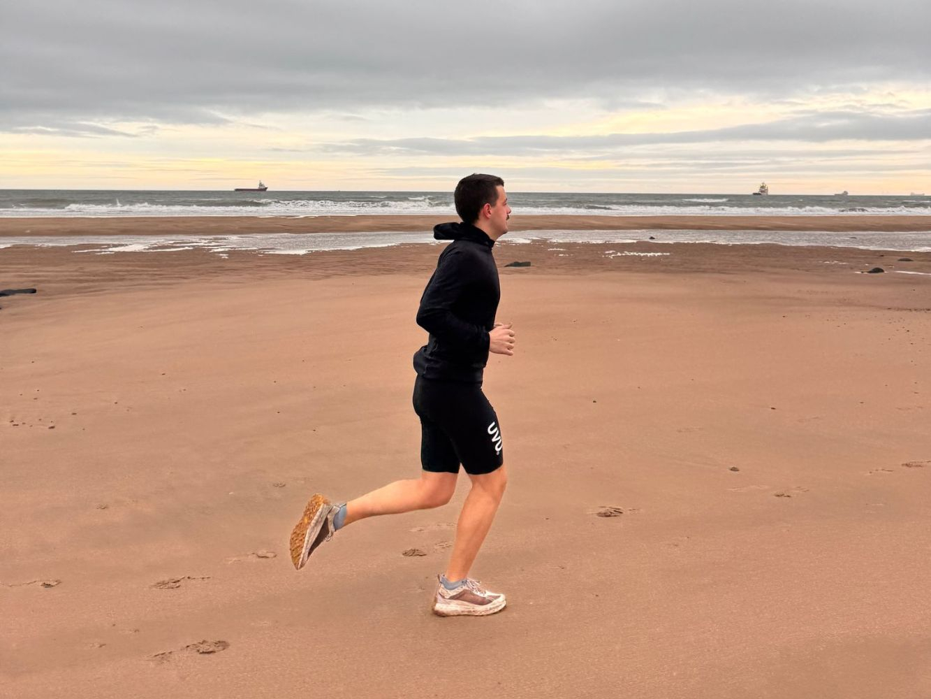 Jayden running along the beach in Aberdeen