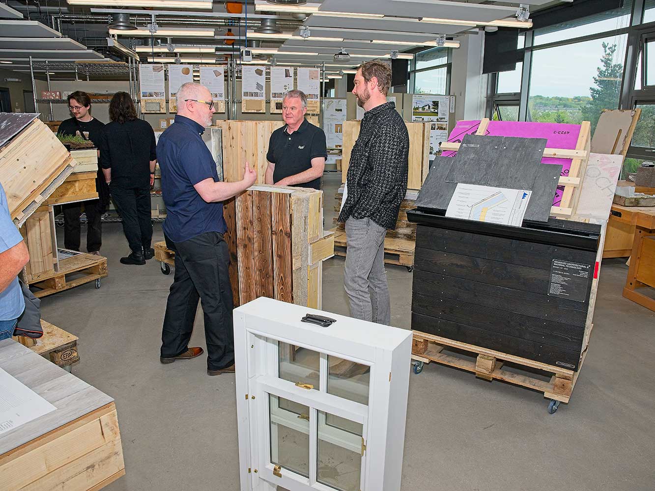 people chatting next to an architectural model