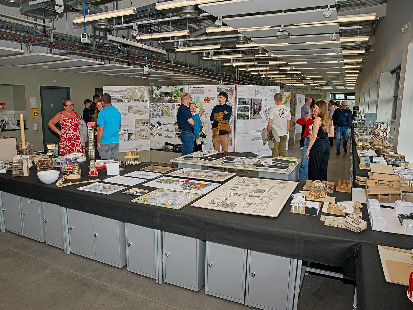 people chatting next to architectural models