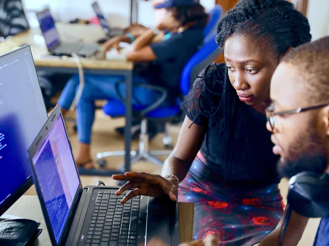 two students looking at code on a monitor