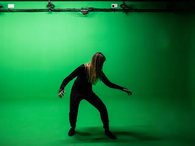 woman posing in front of green screen