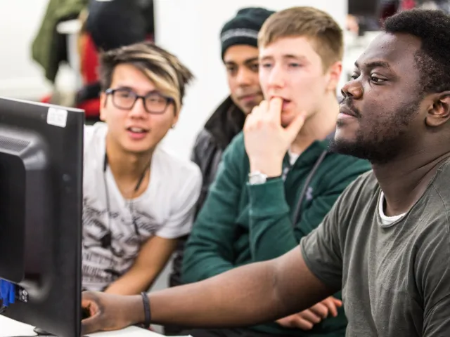 students crowded around a computer