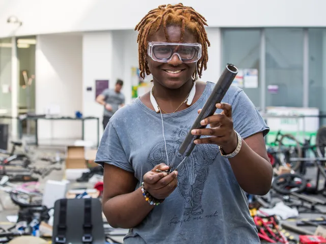 student holding pipe as part of engineering project